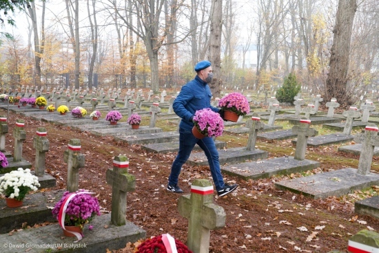 Ustawianie chryzantem na cmentarzu wojskowym