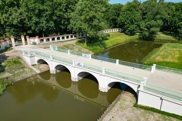 Mostek w Ogrodach Branickich po remoncie. Zlikwidowano schody, są zielone balustrady